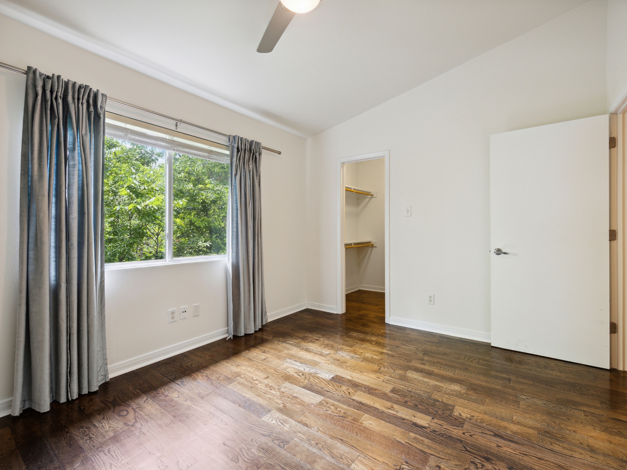 1503 West 9th Street, Unit 204 Austin, TX 78703 - Photo 13 of 21 Bedroom featuring wood-finish flooring, a vaulted ceiling, and a ceiling fan