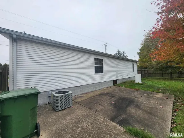 a view of a backyard with plants and a large tree