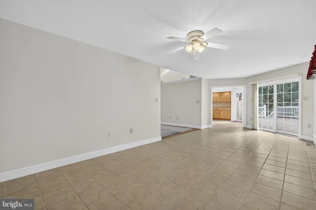 an empty room with a ceiling fan and a bathroom