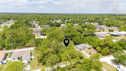 an aerial view of residential houses with outdoor space and trees