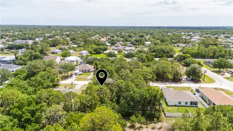 an aerial view of residential houses with outdoor space and trees