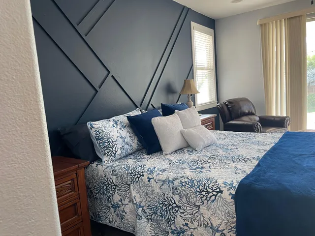 a bed sitting in a bedroom next to a window