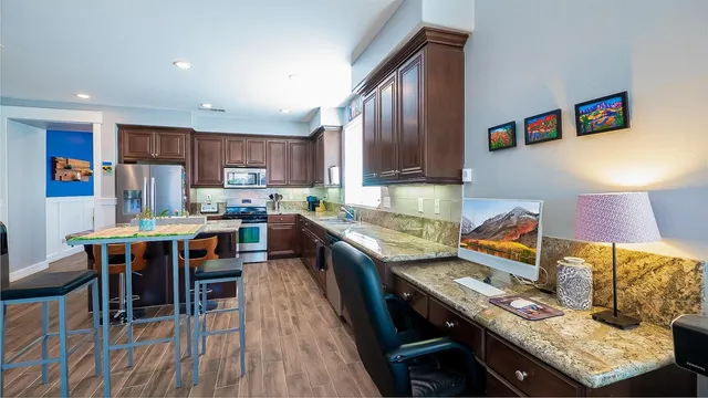 a kitchen with stainless steel appliances granite countertop a stove top oven a sink dishwasher and a dining table with garden view