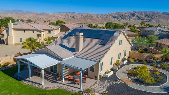 an aerial view of a house with swimming pool and mountain view