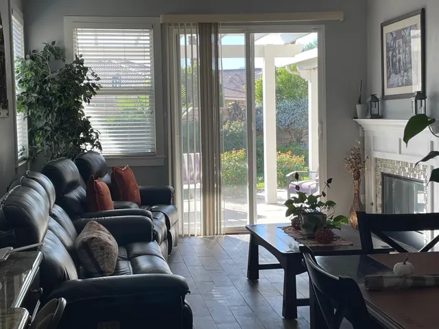 a bedroom with two beds and a dresser next to a window