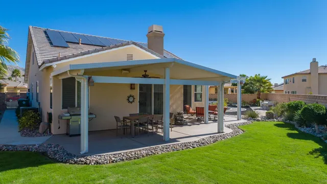 a front view of a house with garden and sitting area