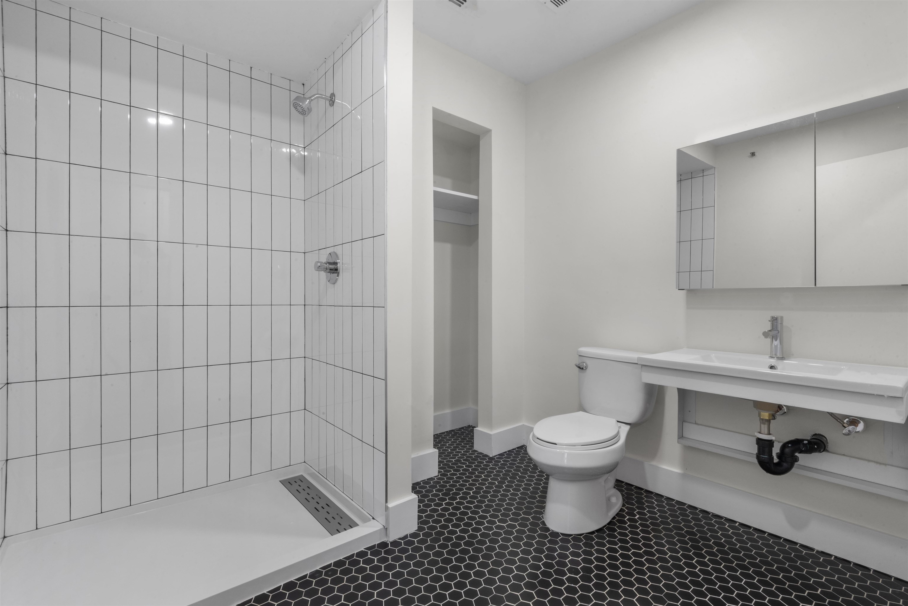 850 West Side Avenue, Unit 13 Jersey City, NJ 07306 - Photo 14 of 16 a bathroom with a sink a toilet and a mirror