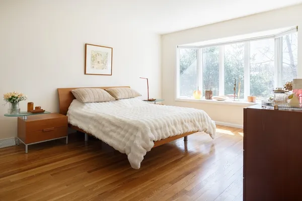 a bedroom with a bed and wooden floor