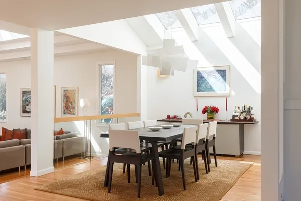 a view of a dining room and livingroom with furniture wooden floor and a rug