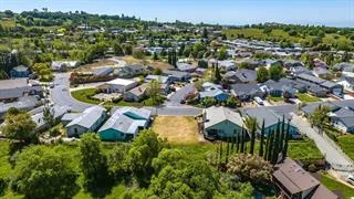 an aerial view of residential houses with outdoor space and trees