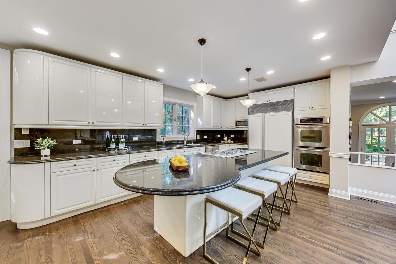 1037 Hillside Road Northbrook, IL 60062 - Photo 7 of 46 a kitchen with a table chairs stove and cabinets