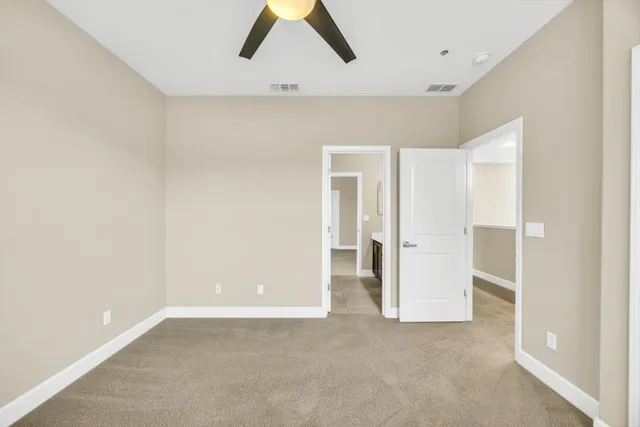 an empty room with closet and windows