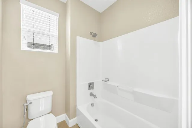 a white bath tub sitting next to a toilet