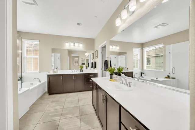 a large bathroom with a double vanity sink a mirror and a bathtub