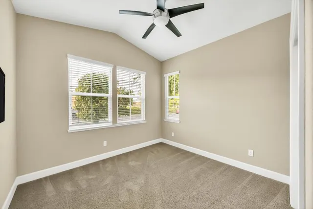 an empty room with a window and a fan