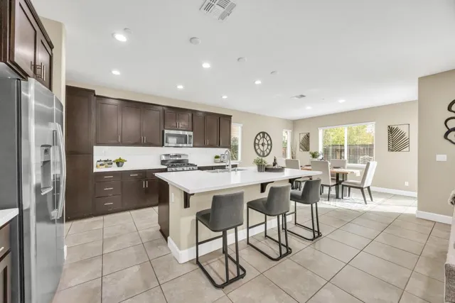 a kitchen with stainless steel appliances granite countertop a refrigerator and a sink