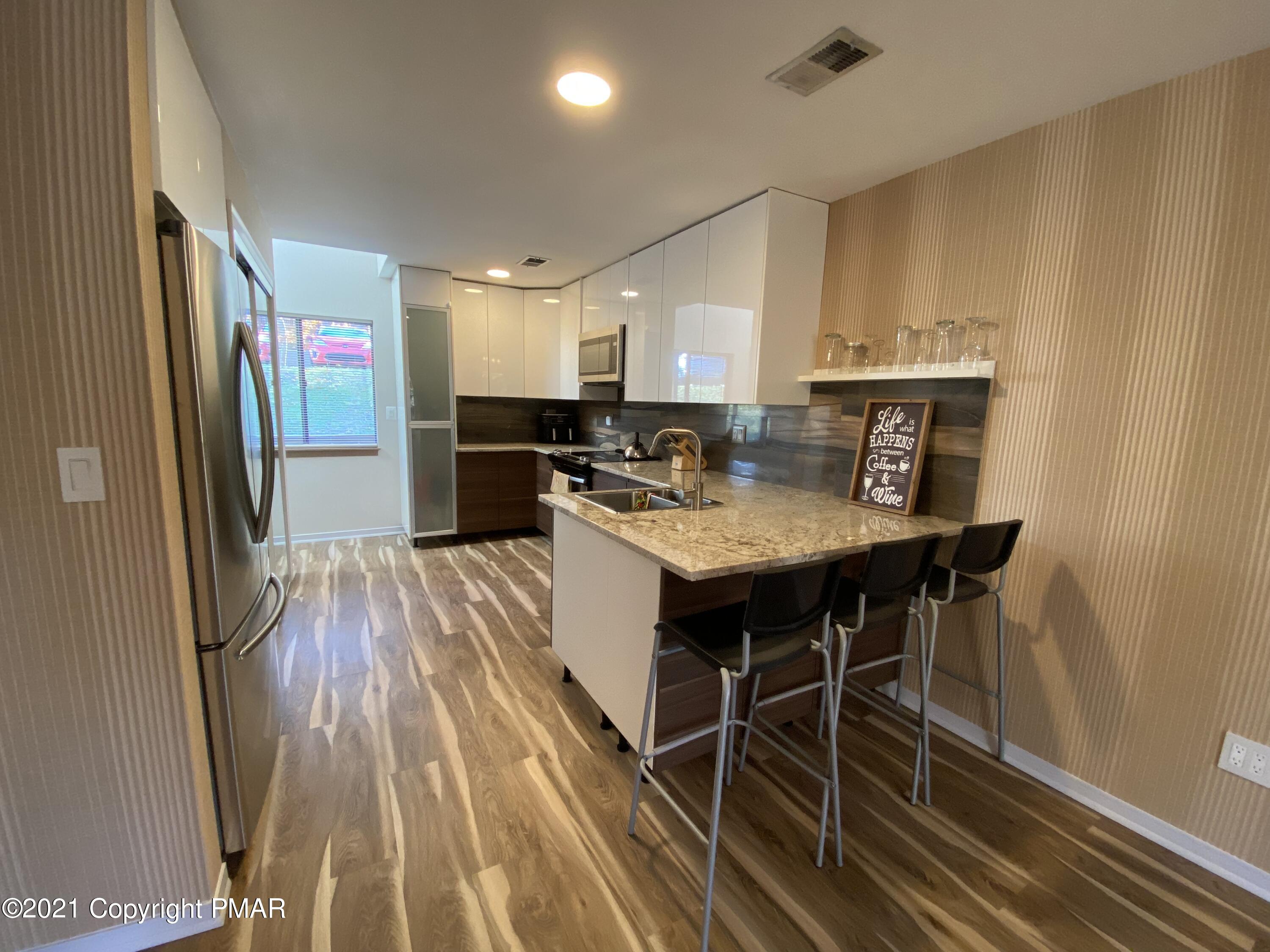 3315 Windemere Drive Bushkill, PA 18324 - Photo 13 of 55 a kitchen with a table chairs refrigerator and a sink