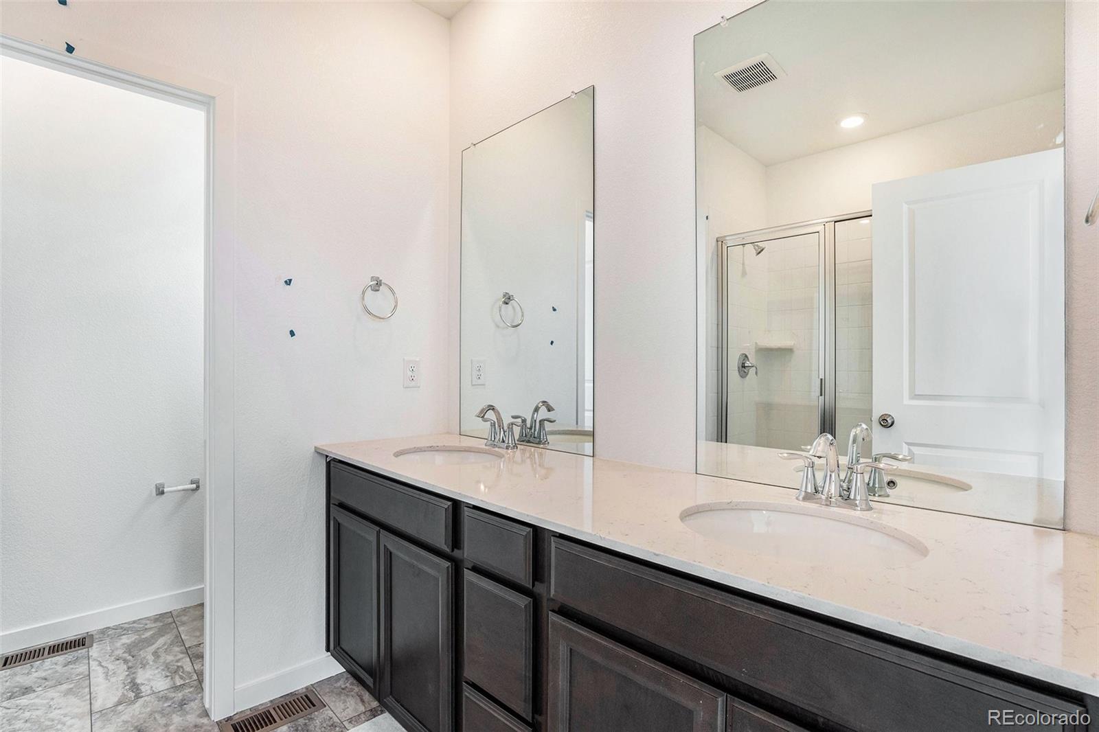 874 Furrow Way Lafayette, CO 80026 - Photo 14 of 27 a bathroom with a double vanity sink a mirror and a shower