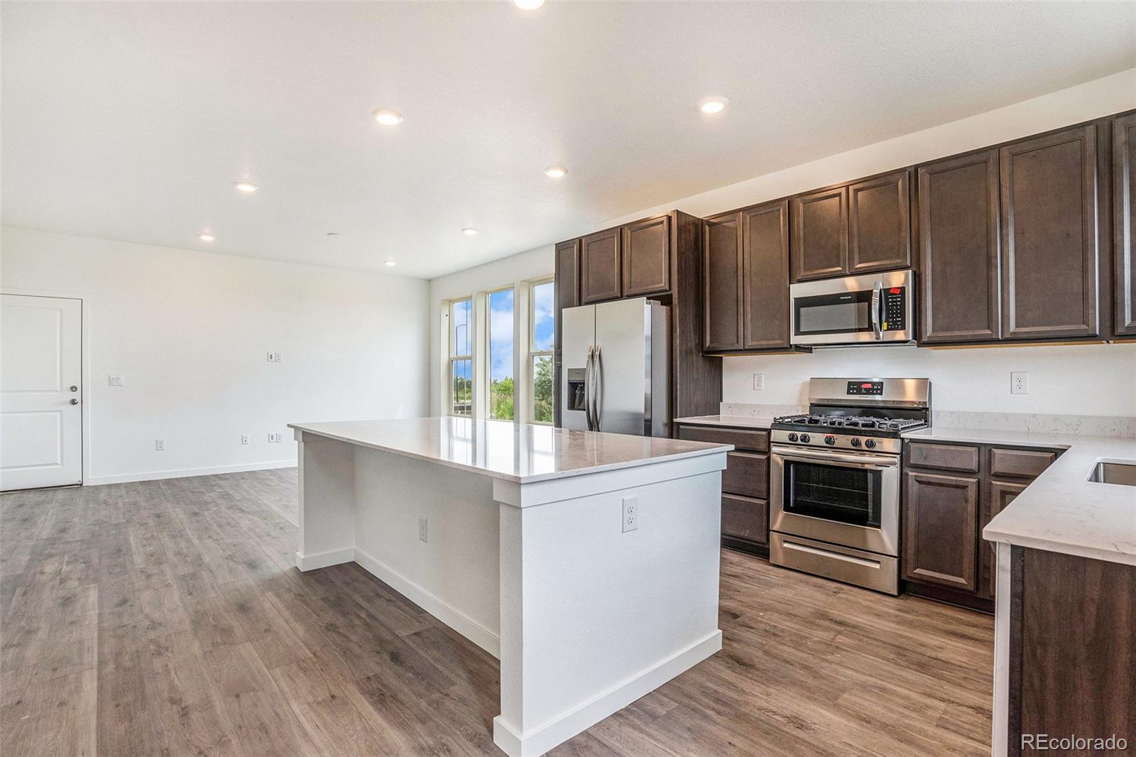 874 Furrow Way Lafayette, CO 80026 - Photo 23 of 27 a kitchen with kitchen island granite countertop stainless steel appliances and wooden cabinets