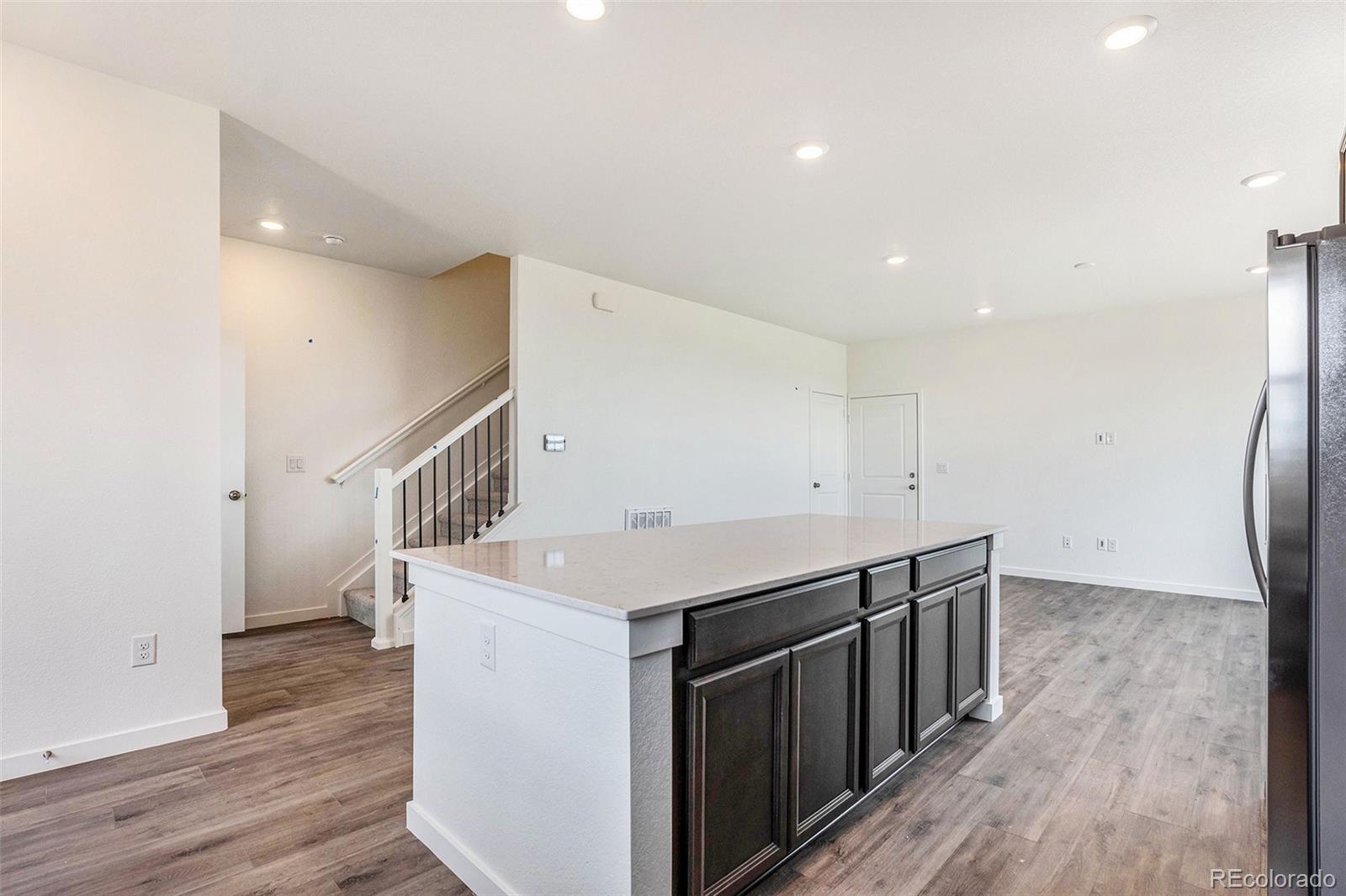 874 Furrow Way Lafayette, CO 80026 - Photo 25 of 27 a hallway with wooden floors and white cabinets