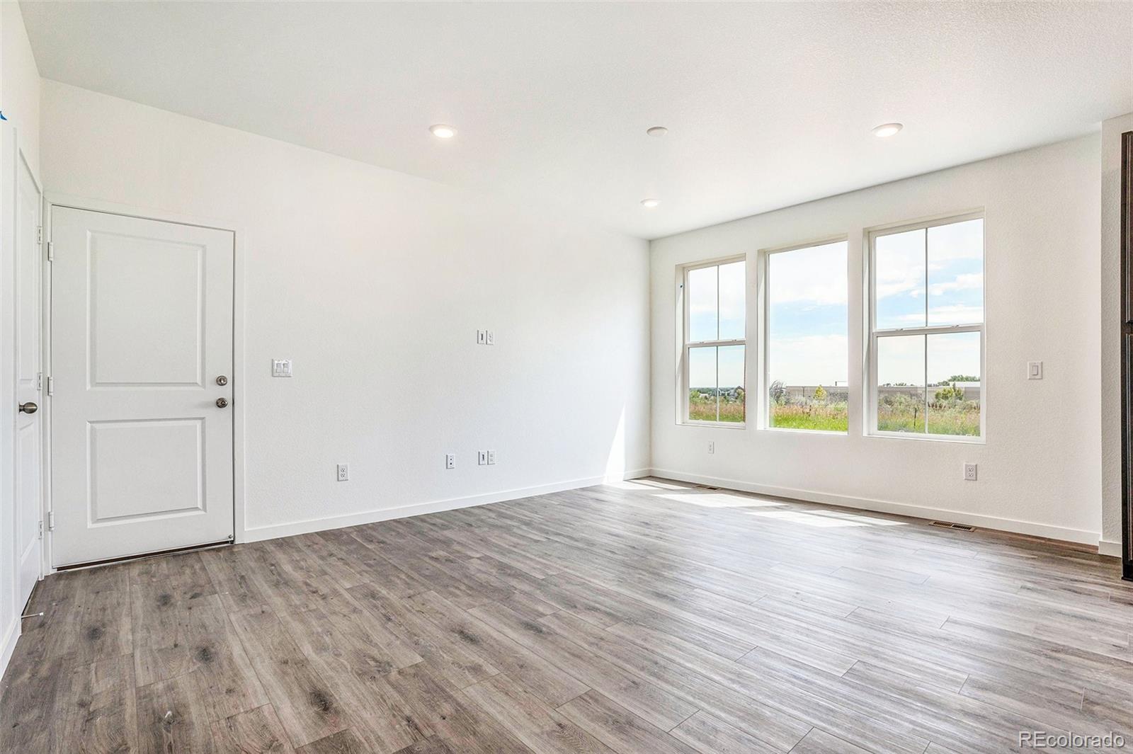 874 Furrow Way Lafayette, CO 80026 - Photo 8 of 27 a view of an empty room with wooden floor and a window