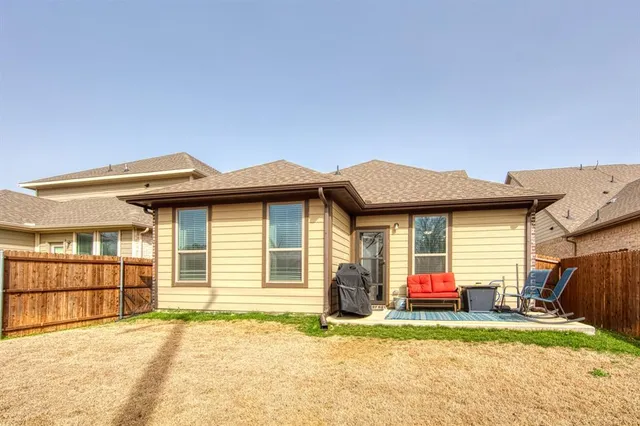 a backyard of a house with barbeque oven table and chairs