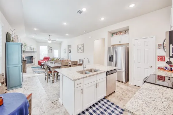 a kitchen with stainless steel appliances kitchen island granite countertop a refrigerator and a sink