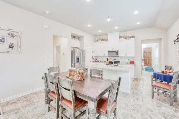 a dining room with kitchen island stainless steel appliances furniture a dining table and chairs
