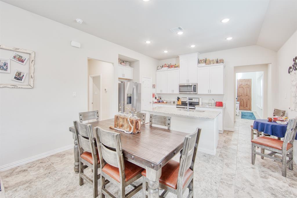 145 Cole Road Pilot Point, TX 76258 - Photo 5 of 14 a dining room with kitchen island stainless steel appliances furniture a dining table and chairs