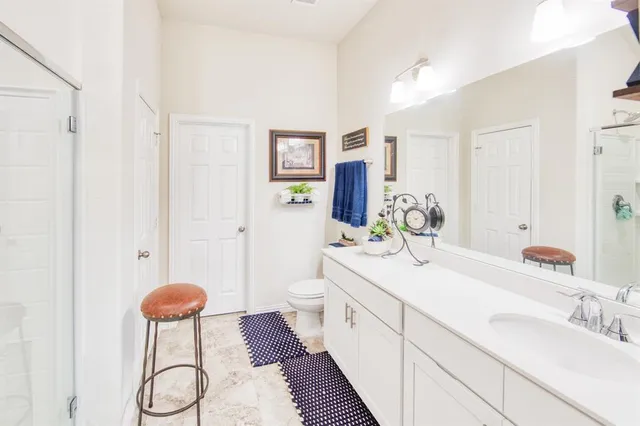 a spacious bathroom with a granite countertop sink and a mirror
