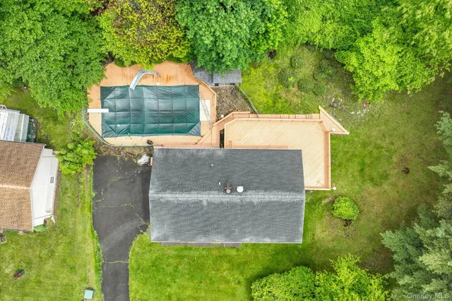 an aerial view of a house with a yard and a large tree