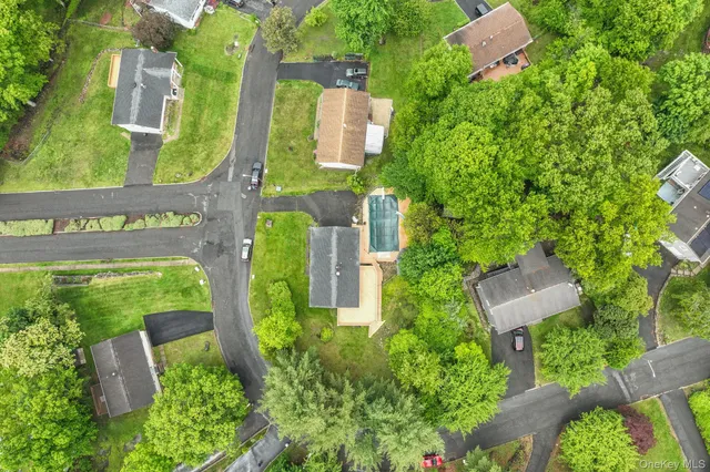 an aerial view of residential house with outdoor space and trees all around