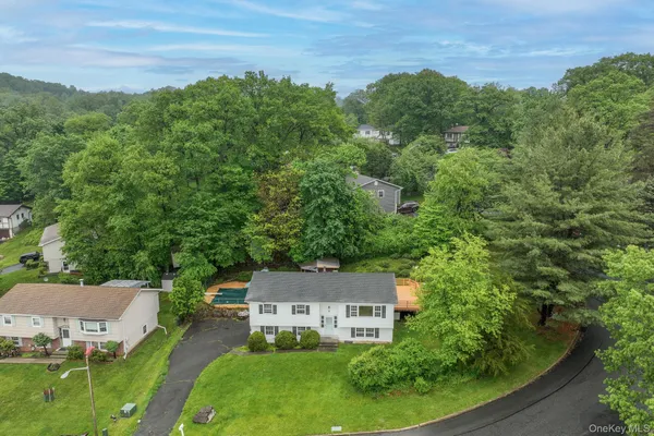 an aerial view of a house with pool outdoor seating and trees