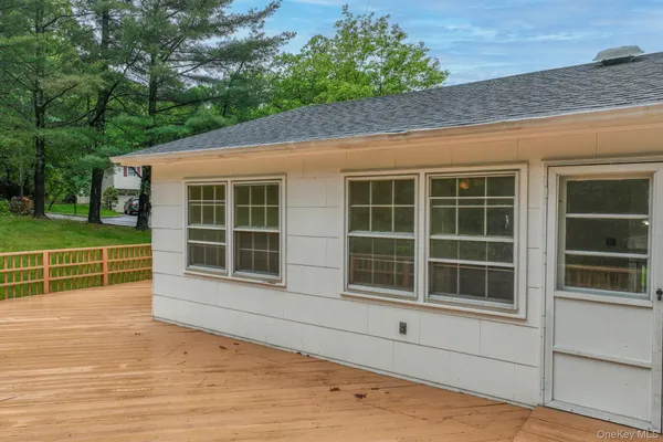 a view of a house with a large window and wooden fence