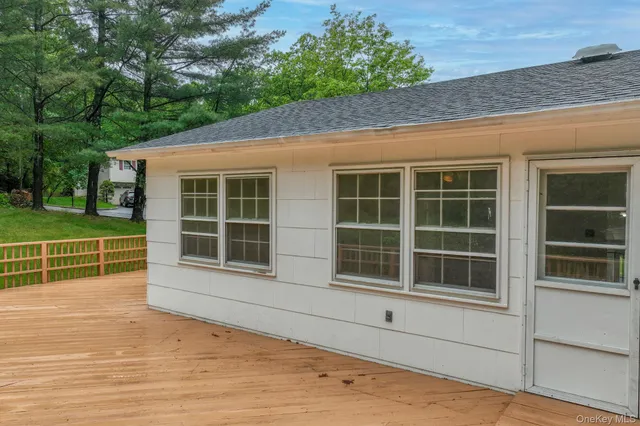 a view of a house with a large window and wooden fence