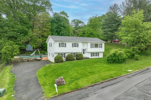a view of a house with a yard and potted plants
