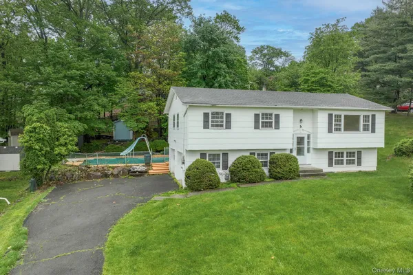 a view of a house with a yard and a tree