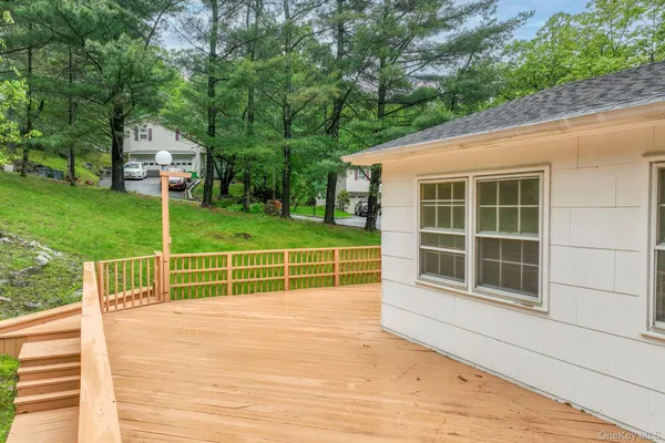 a view of a house with a wooden deck and a big yard