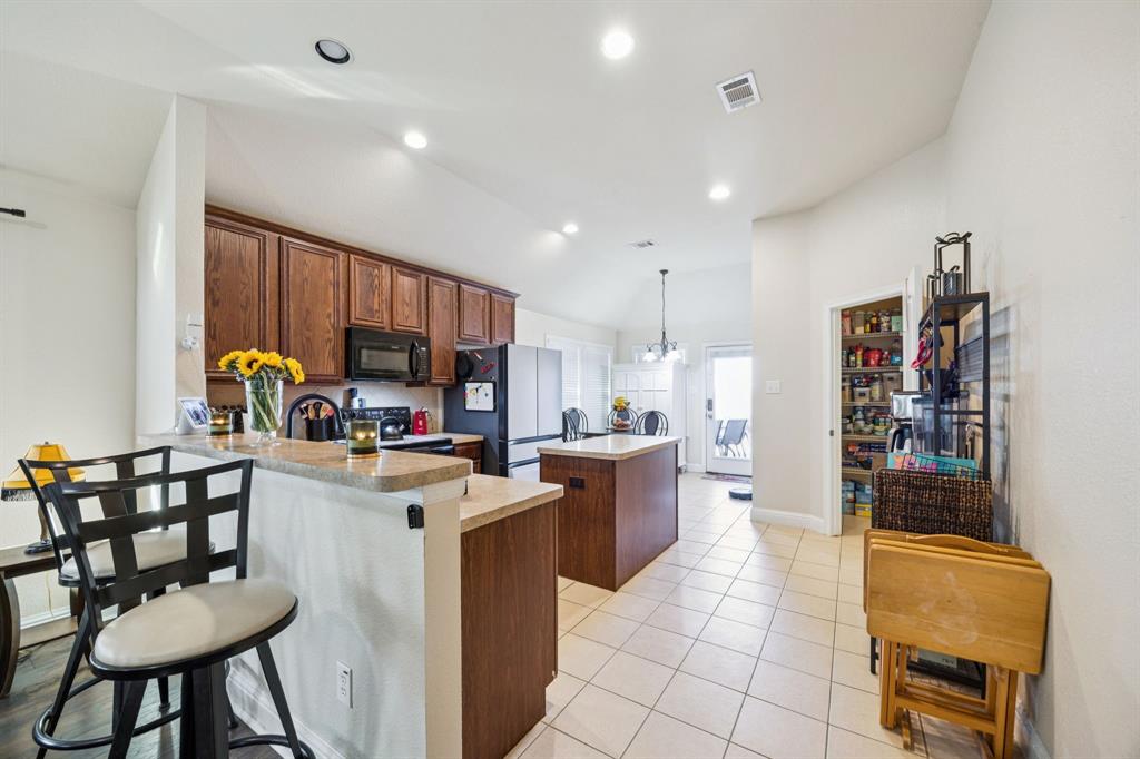 1601 Applegate Way Royse City, TX 75189 - Photo 6 of 28 a kitchen with stainless steel appliances kitchen island granite countertop a table chairs and a refrigerator