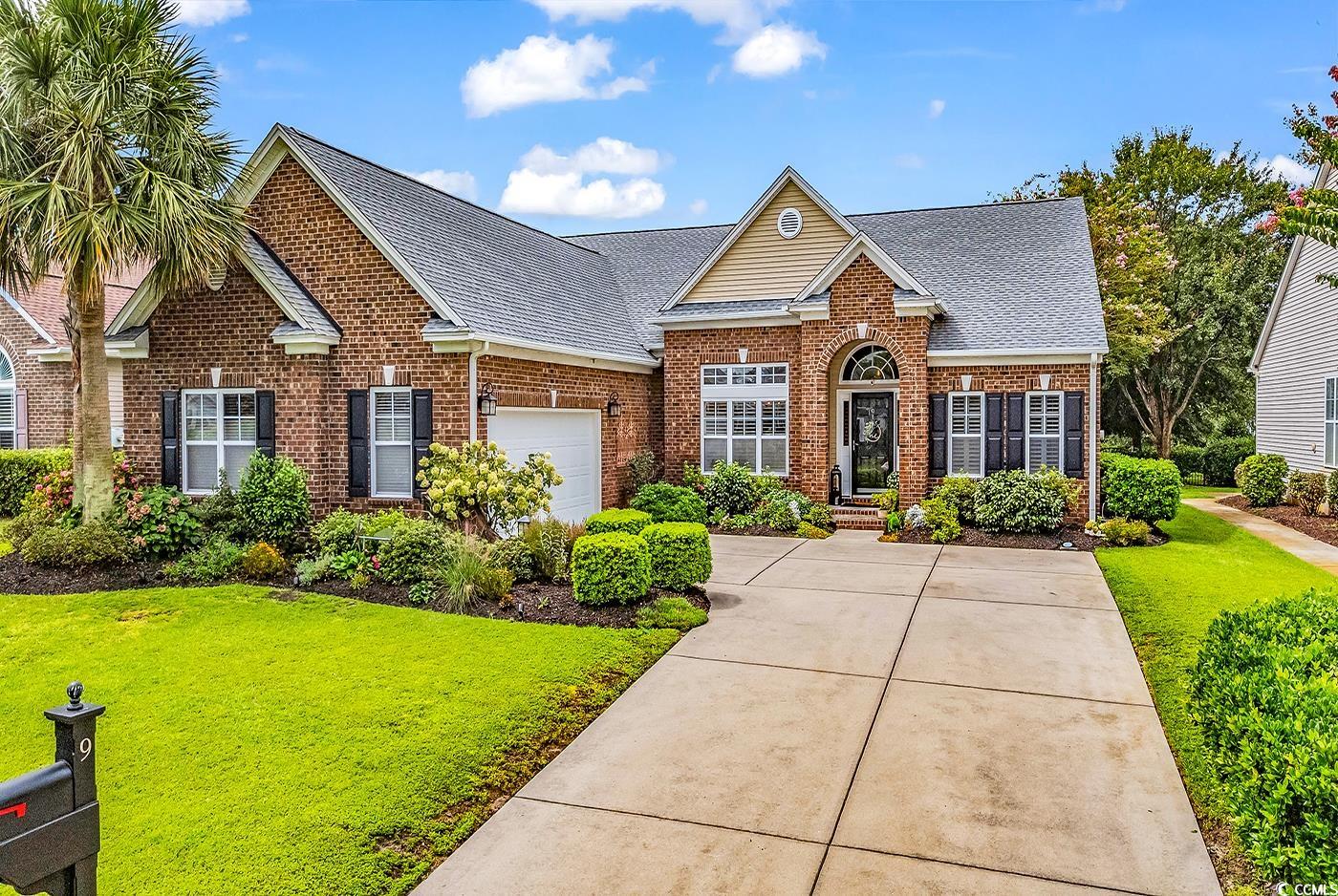 9 Saltwind Loop Murrells Inlet, SC 29576 - Photo 1 of 38 Traditional home featuring roof with shingles, brick siding, an attached garage, and a front lawn