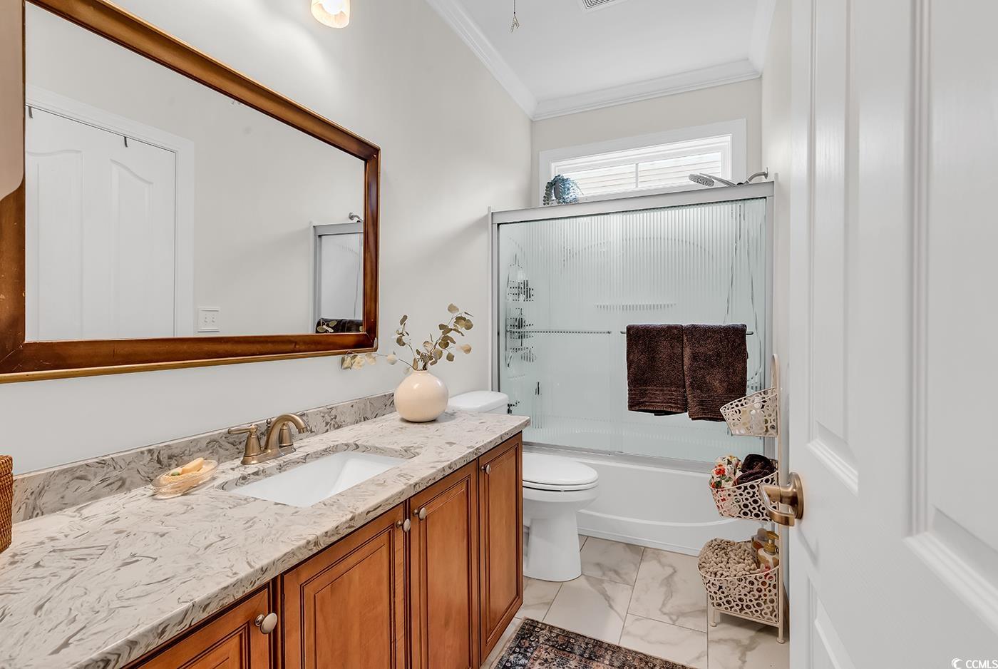 9 Saltwind Loop Murrells Inlet, SC 29576 - Photo 25 of 38 Bathroom featuring crown molding, shower / bath combination with glass door, vanity, and light marble finish floors