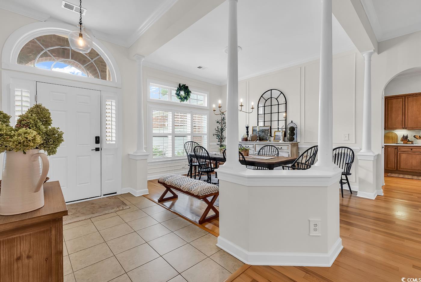 9 Saltwind Loop Murrells Inlet, SC 29576 - Photo 3 of 38 Entryway featuring crown molding, decorative columns, light tile patterned floors, and a chandelier