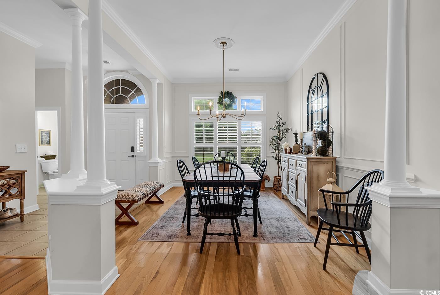 9 Saltwind Loop Murrells Inlet, SC 29576 - Photo 6 of 38 Dining room featuring ornate columns, ornamental molding, light wood-style flooring, and a chandelier