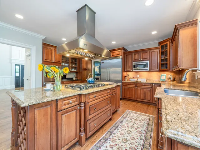 a kitchen with stainless steel appliances kitchen island granite countertop a sink stove and refrigerator