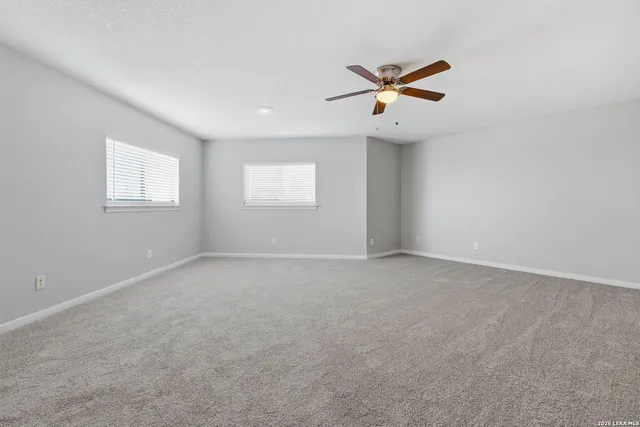 an empty room with a window and a ceiling fan