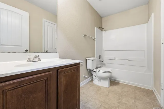 a bathroom with a granite countertop toilet a sink and a mirror
