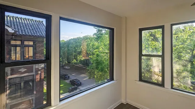 a view of a livingroom with wooden floor and a kitchen