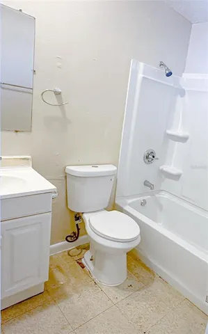 a white toilet sitting next to a bathroom sink and a tub