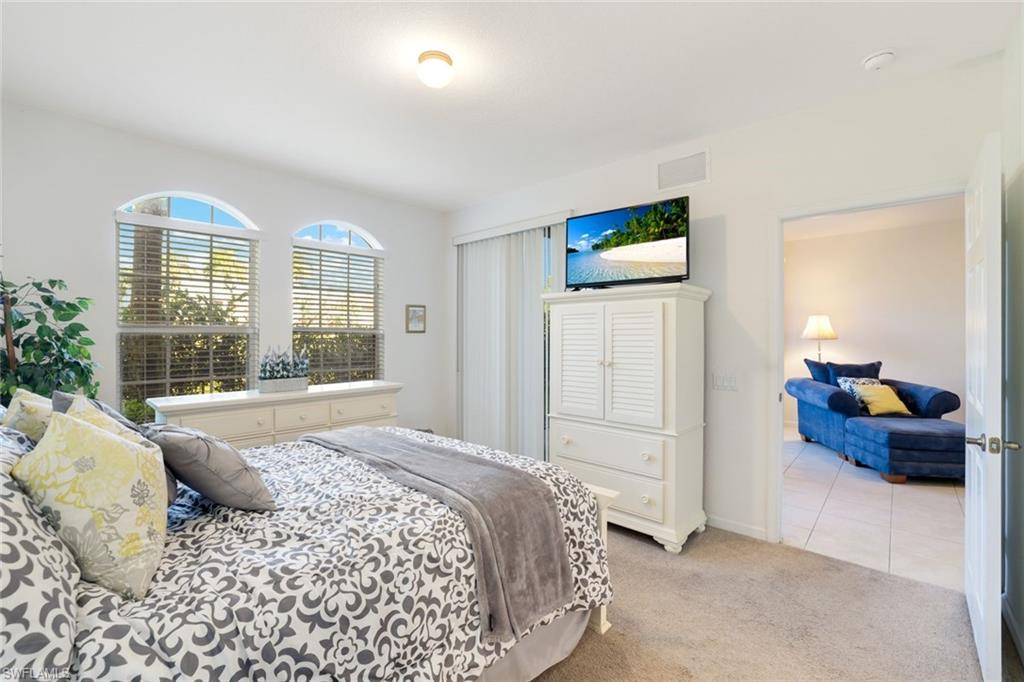 10049 Heather Lane, Unit 101 Naples, FL 34119 - Photo 19 of 28 Tiled bedroom with carpet floors and baseboards