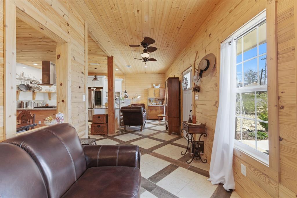 118 Heath Street Hico, TX 76457 - Photo 10 of 39 a living room with furniture a flat screen tv and a floor to ceiling window